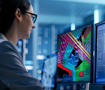 Woman analyzing BIM designs on two computer monitors